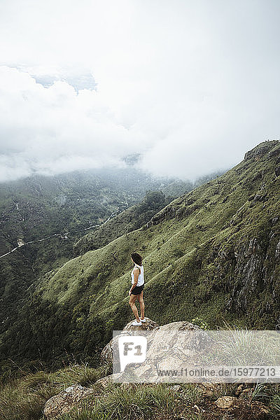 Sri Lanka  Provinz Uva  Ella  Wanderin steht auf einem Felsblock am Little Adams Peak