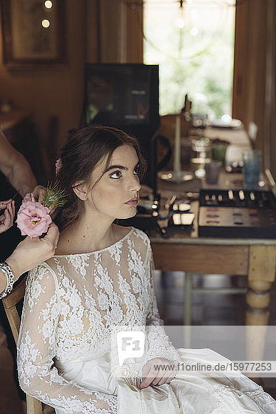 Hairdresser with flower for hair of bride