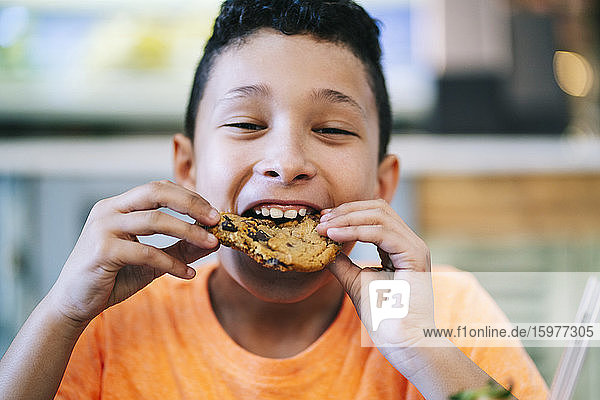 Portrait of boy enjoying fresh cookie at restaurant