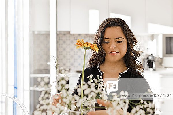 Junge Frau mit Down-Syndrom arrangiert Blumen zu Hause