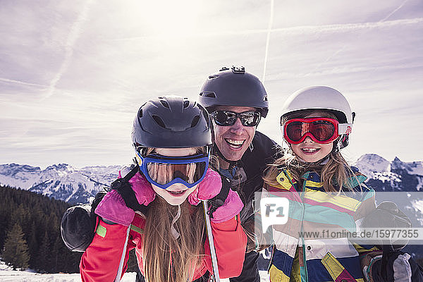 Glücklicher Vater umarmt seine Töchter beim Skiurlaub am Spitzingsee  Bayern  Deutschland