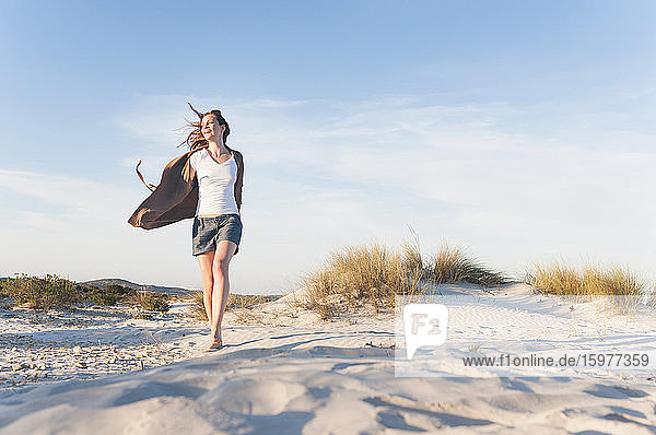 Glückliche Frau  die durch Stranddünen spaziert  Sardinien  Italien