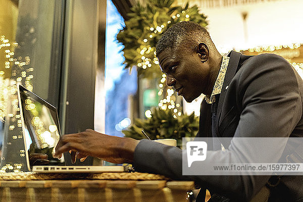 Junger Geschäftsmann arbeitet am Laptop in einem Café