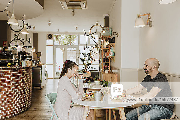 Smiling man and woman sitting at table in a coffee shop
