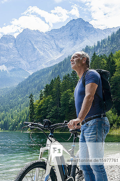 Senior man with e-bike at Eibsee lakeside