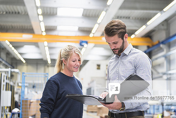 Man with a folder and woman in a factory