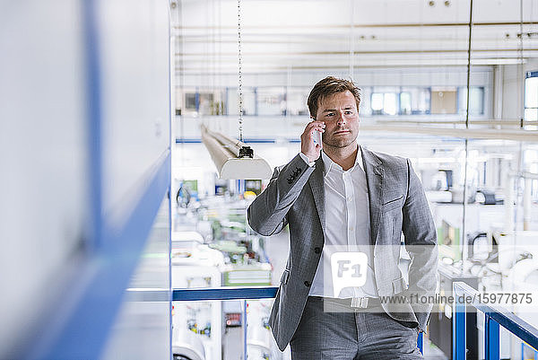 Businessman on the phone in a factory