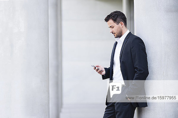 Businessman wearing suit looking on smartphone