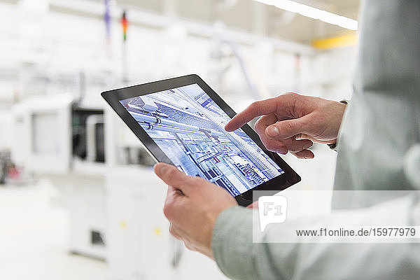 Close-up of man using tablet in a factory