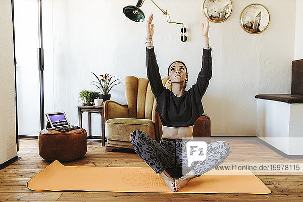 Junge Frau übt Yoga zu Hause