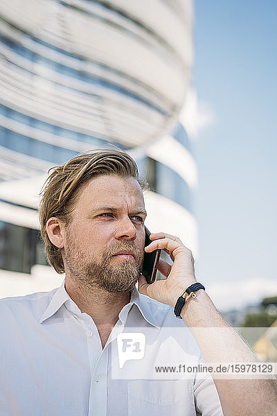 Porträt eines Geschäftsmannes beim Telefonieren in der Stadt