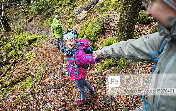 Mädchen führt ihre Mutter auf einem Wanderweg im Nordschwarzwald im Winter