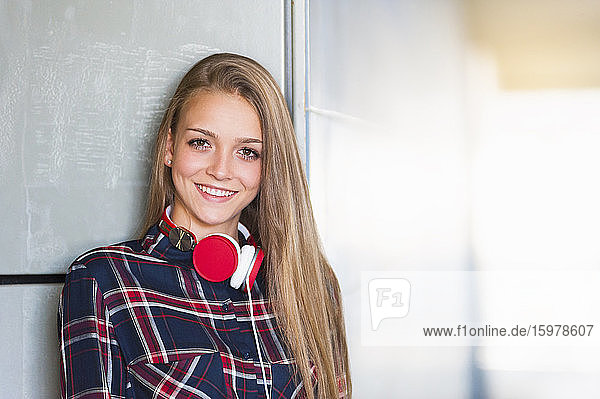 Porträt einer lächelnden jungen Frau mit Kopfhörern