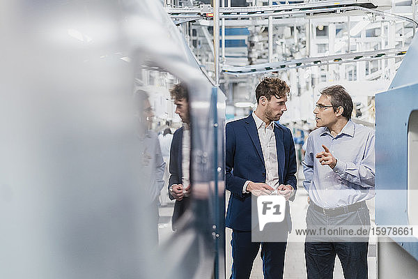 Two businessmen having a meeting in a factory