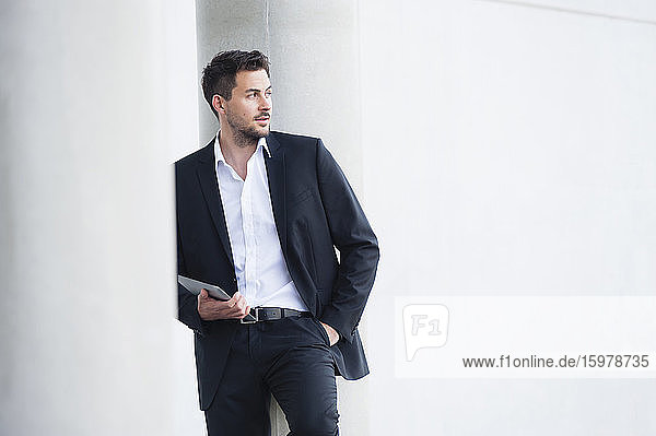 Businessman wearing suit and holding digital tablet