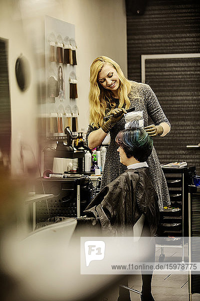 Woman getting highlights at hairdresser