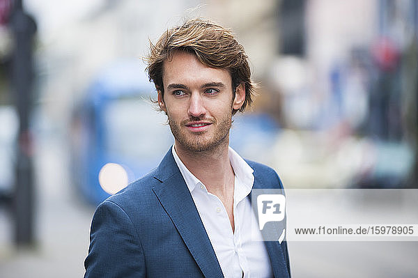 Portrait of young businessman with stubble outdoors