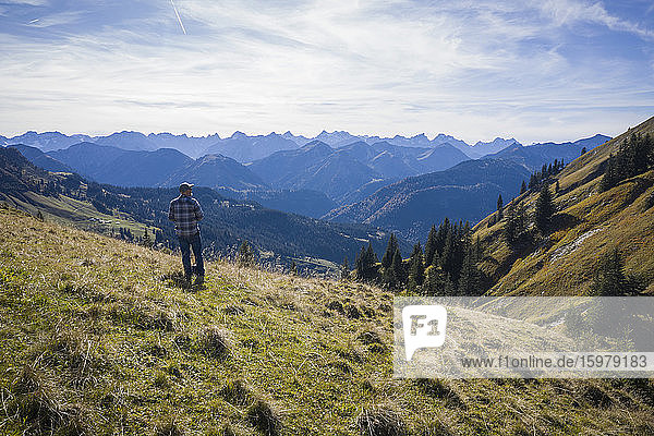 Österreich  Tirol  Eben am Achensee  Männlicher Wanderer bewundert grüne bewaldete Berge im Herbst