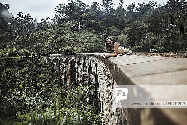 Sri Lanka  Provinz Uva  Demodara  Porträt einer erwachsenen Frau  die sich an die Nine Arch Bridge lehnt