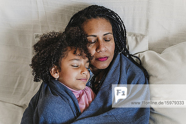 Portrait od mother and her little daughter resting on the couch