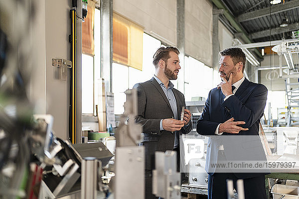 Two businessmen having a meeting in a factory