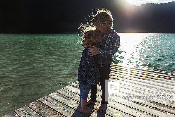 Bruder küsst Schwester auf der Uferpromenade am Achensee  Bundesland Tirol  Österreich