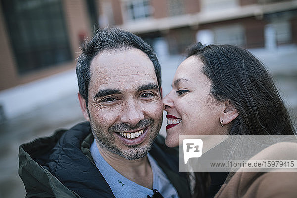 Glücklicher Mann nimmt Selfie mit Frau im Freien