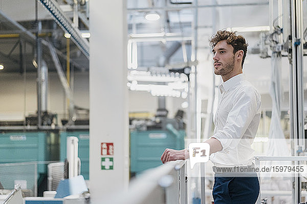 Young businessman standing in a factory