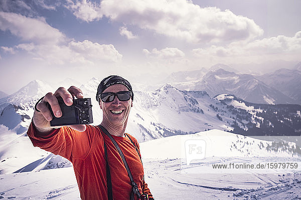 Happy mature man taking selfie through camera while enjoying ski holiday at Achenkirch  Tyrol  Austria