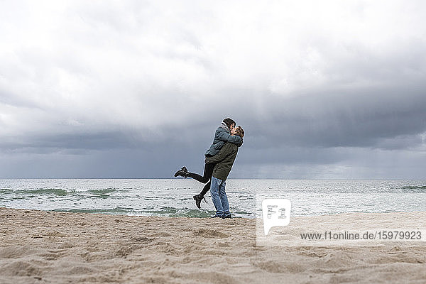 Russia  Kaliningrad Oblast  Zelenogradsk  Adult couple kissing on sandy coastal beach of Baltic Sea