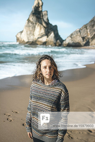 Schöne junge Frau  die an einer Felsformation am Praia da Ursa steht  Lisboa  Portugal