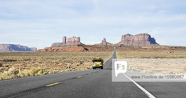 School bus on desert road at famous Monument Valley Tribal Park against sky  Utah  USA