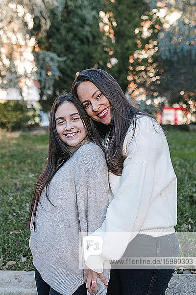 Mutter und Tochter umarmen sich in einem Park