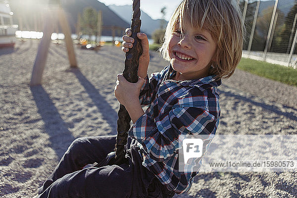 Fröhlicher Junge beim Schwingen am Seil am Achensee  Bundesland Tirol  Österreich