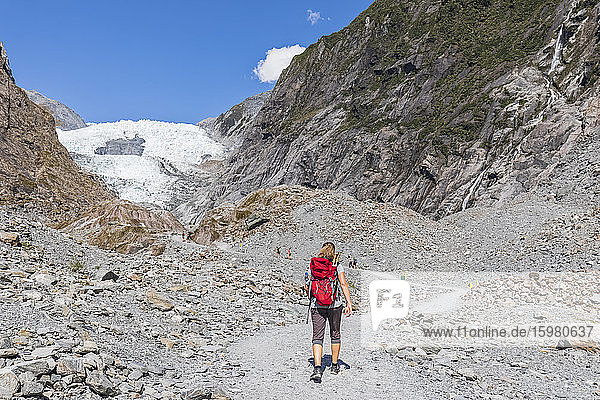 Neuseeland  Westland District  Franz Josef  Rucksacktouristin beim Wandern im Franz Josef Gletscher