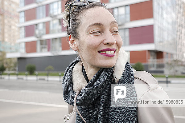 Smiling beautiful woman with white rats on scarf against building