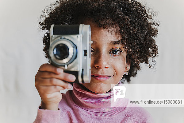Portrait of smiling little girl with vintage camera