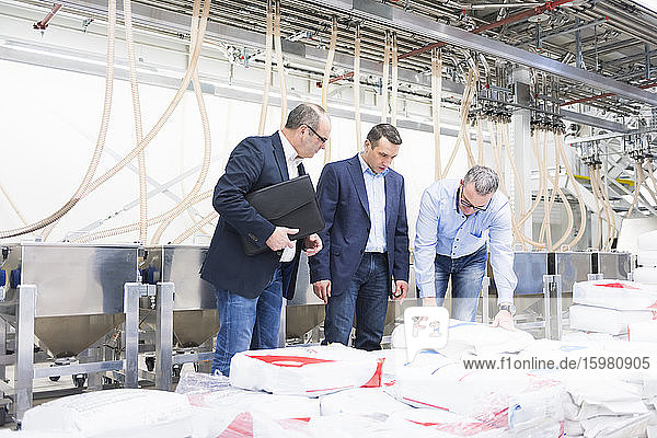Three businessmen having a discussion in a factory