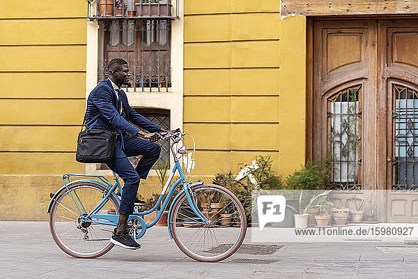 Young businessman riding bicycle in the city