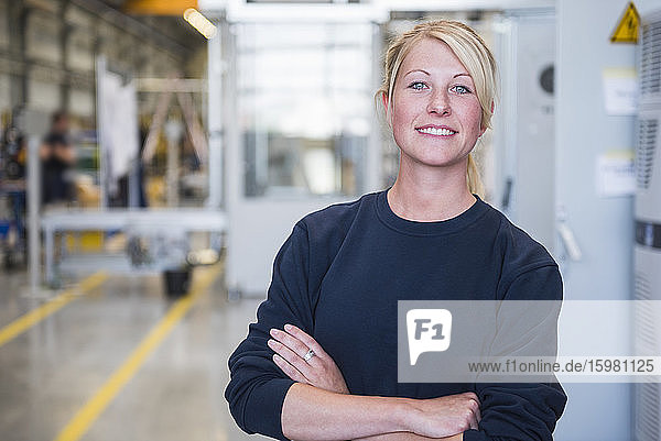 Porträt einer selbstbewussten jungen Frau in einer Fabrik