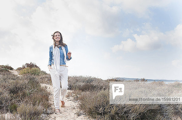 Happy woman strolling in beach dunes  Sardinia  Italy