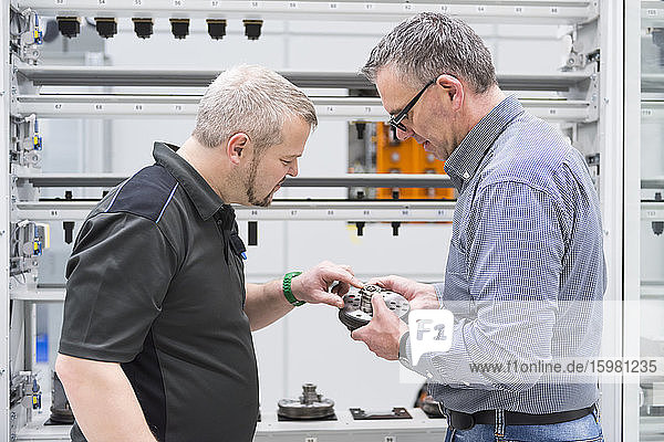 Two men examining product in a factory