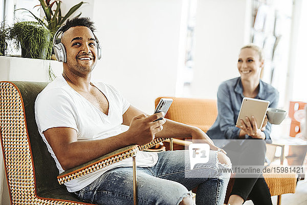 Man and woman relaxing with electronic devices