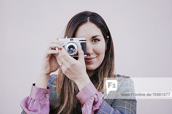 Porträt einer lächelnden Frau mit einer alten Kamera