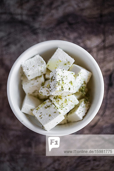Bowl of sliced feta cheese with olive oil and oregano