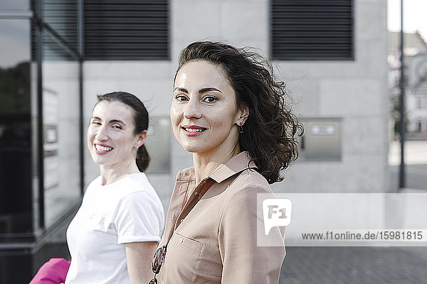 Porträt von glücklichen multiethnischen Geschäftsfrauen vor einem Bürogebäude