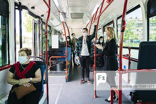 Fahrgäste mit Schutzmasken in einem öffentlichen Bus  Spanien