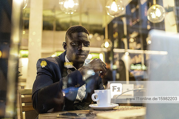 Portrait of young businessman working on laptop in a coffee shop