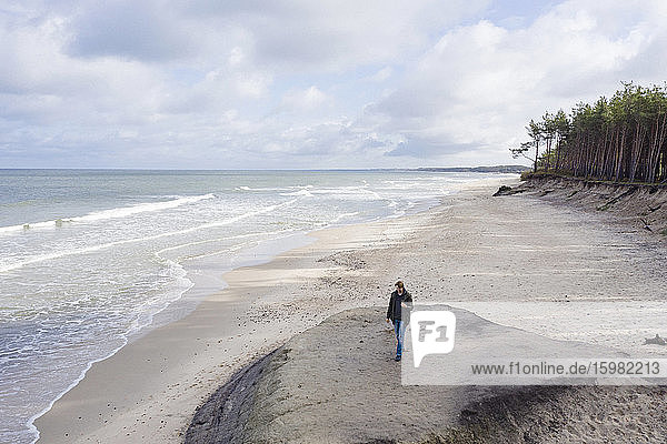 Russia  Kaliningrad Oblast  Zelenogradsk  Man walking along sandy coastal beach of Baltic Sea