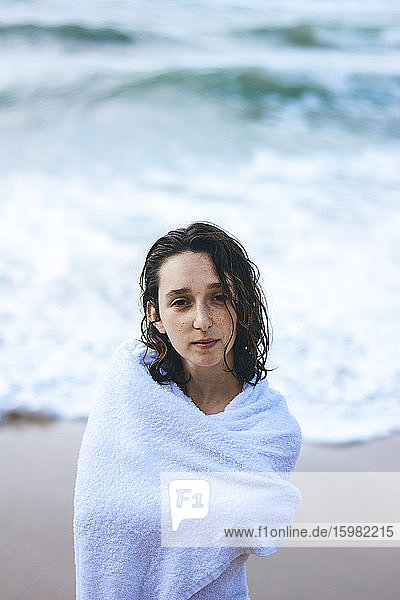 Young woman wrapped in white towel against sea at Praia da Ursa  Lisboa  Portugal